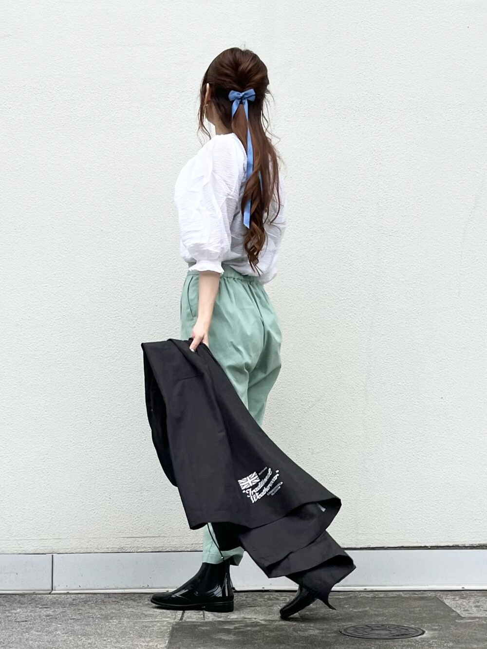 ブラック系のレインシューズ、ホワイト系のトップス、グリーン系のその他パンツを着用したレディースの夏コーディネートの4枚目の写真