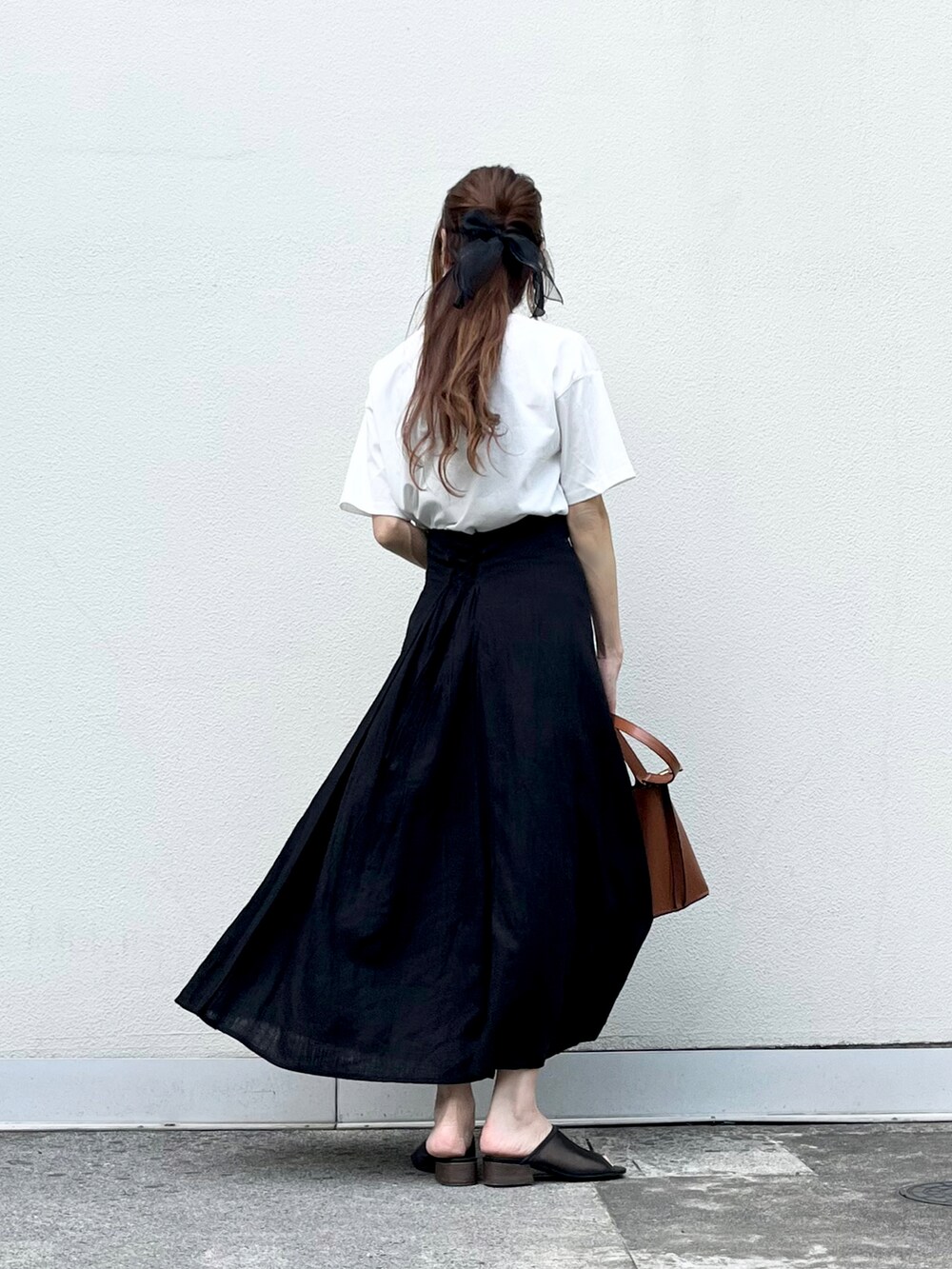 ブラウン系のバッグ、ブラック系のスカート、ブラック系のその他シューズを着用したレディースの夏コーディネートの4枚目の写真