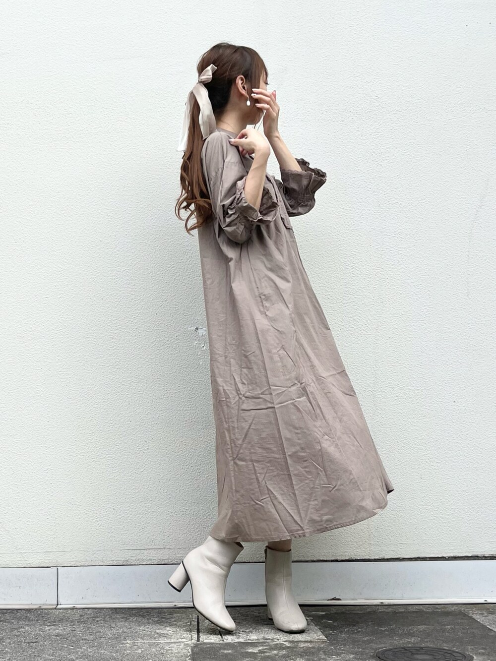 ブラウン系のワンピース、ホワイト系のブーツ、ベージュ系のヘアゴムを着用したレディースの夏コーディネートの3枚目の写真
