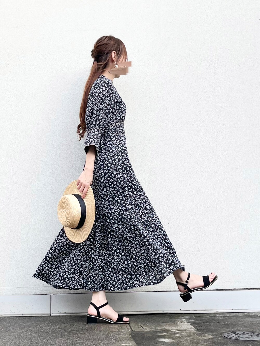 ブラック系のワンピース、ブラック系のサンダル、ベージュ系のハットを着用したレディースの夏コーディネートの3枚目の写真