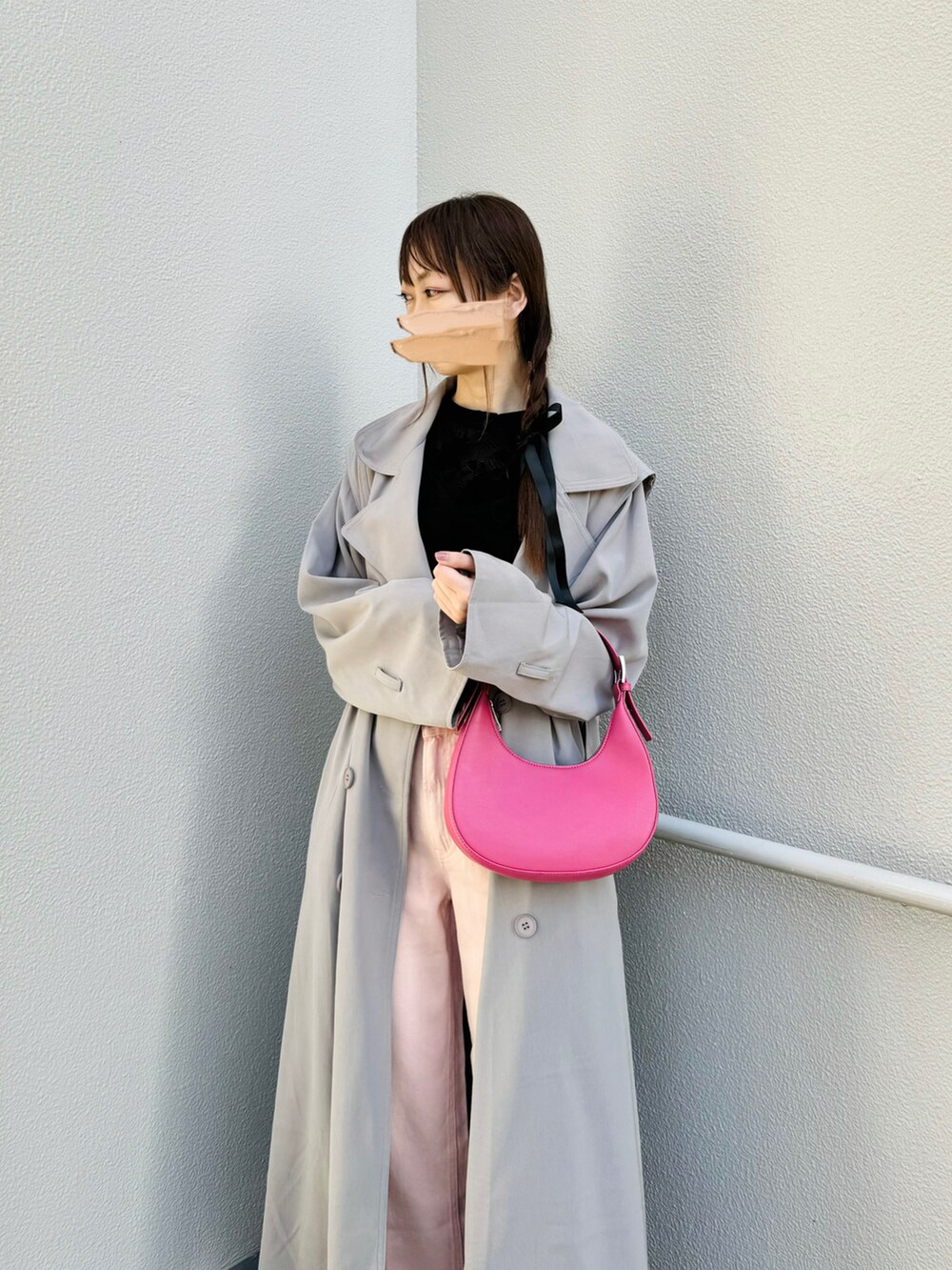 ブラック系のパンプス、グレー系のトレンチコート、ピンク系のハンドバッグを着用したレディースの春コーディネートの2枚目の写真