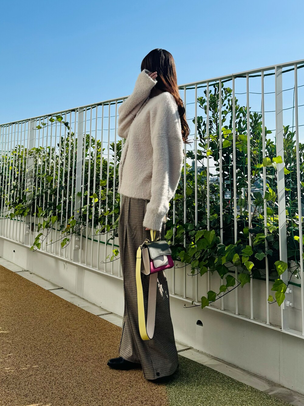 ピンク系のハンドバッグ、ブラック系のブーツ、ベージュ系のカーディガン/ボレロを着用したレディースの秋コーディネートの3枚目の写真