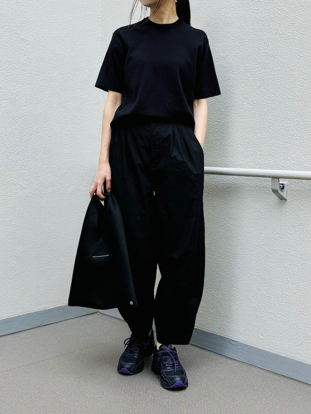 ブラック系のシューズ、ブラック系のトートバッグ、ブラック系のパンツを着用したレディースの夏コーディネートの2枚目の写真