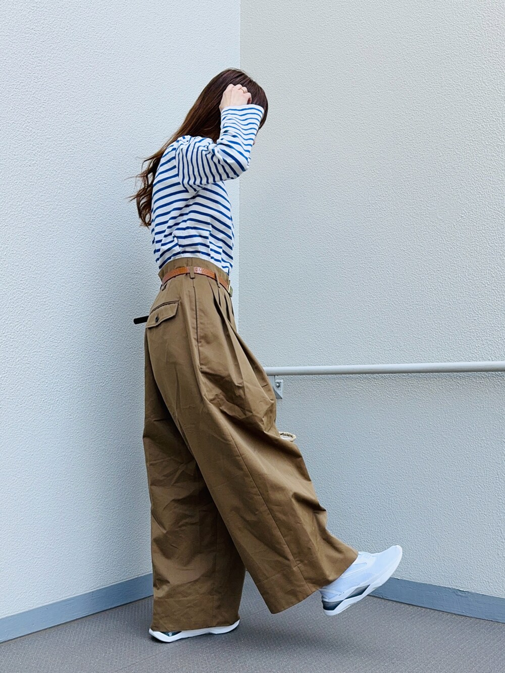 ブルー系のTシャツ/カットソー、ホワイト系のスニーカー、ブラウン系のパンツを着用したレディースの春コーディネートの2枚目の写真