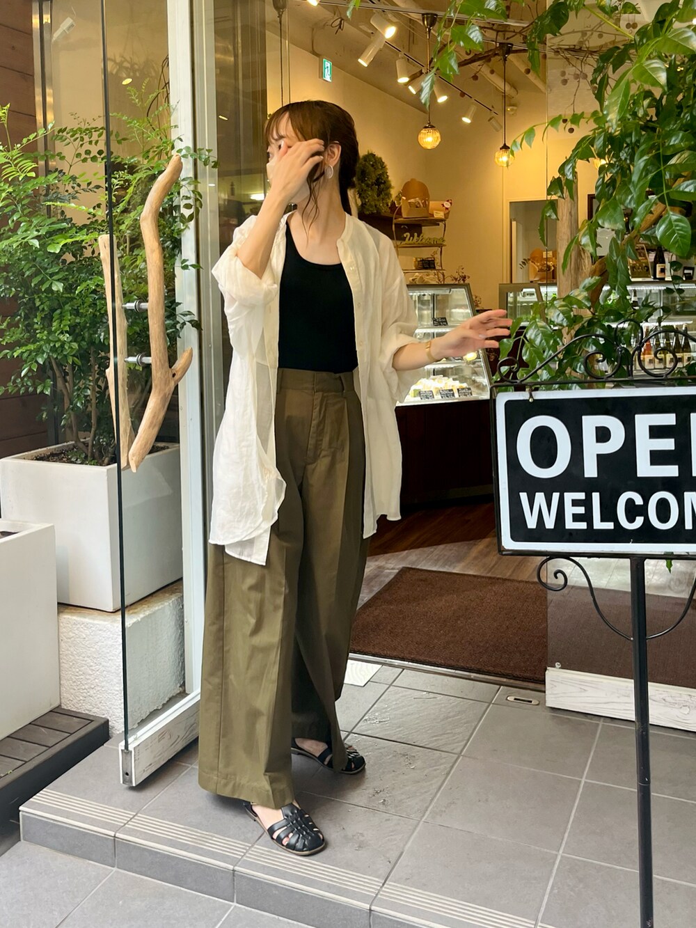 ブラック系のタンクトップ、グリーン系のその他パンツ、ブラック系のサンダルを着用したレディースの夏コーディネートの2枚目の写真