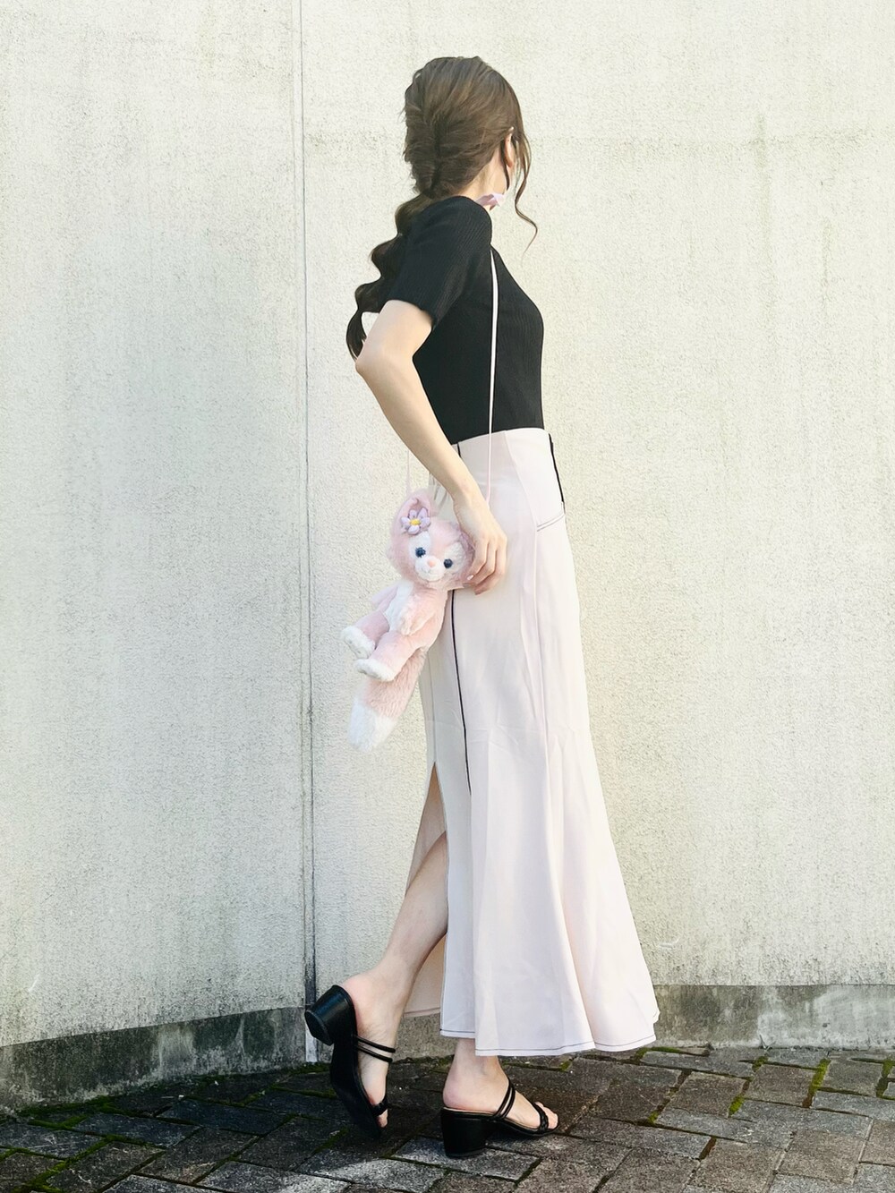 ブラック系のニット/セーター、ベージュ系のスカート、ブラック系のサンダルを着用したレディースの夏コーディネートの5枚目の写真