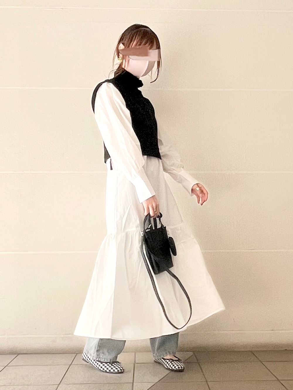 ホワイト系のワンピース、グリーン系のパンプス、ブラック系のショルダーバッグを着用したレディースの冬コーディネートの5枚目の写真