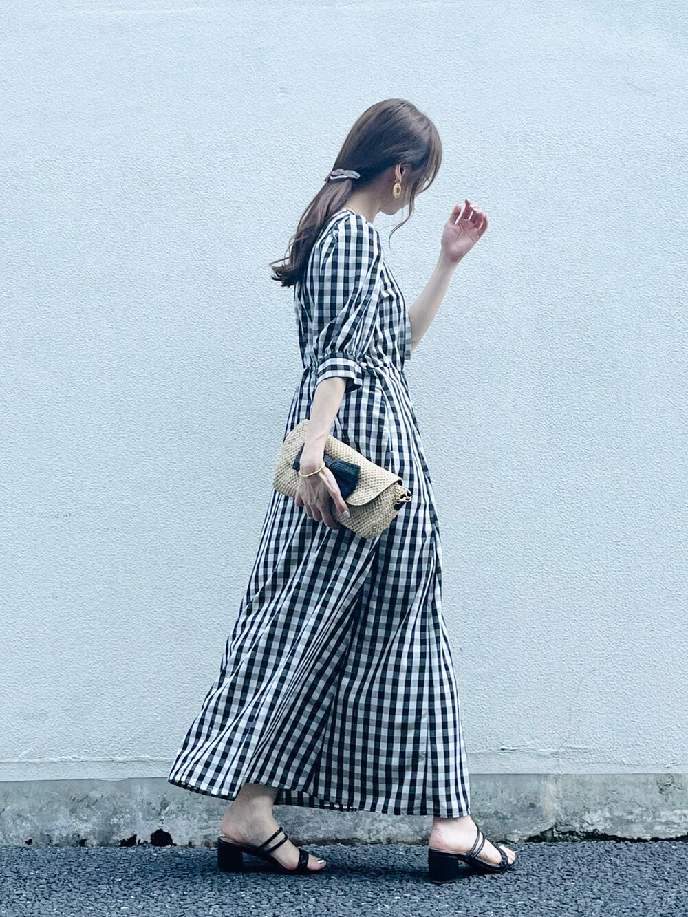 ブラック系のワンピース/ドレス、ベージュ系のバッグ、ブラック系のサンダルを着用したレディースの春コーディネートの4枚目の写真