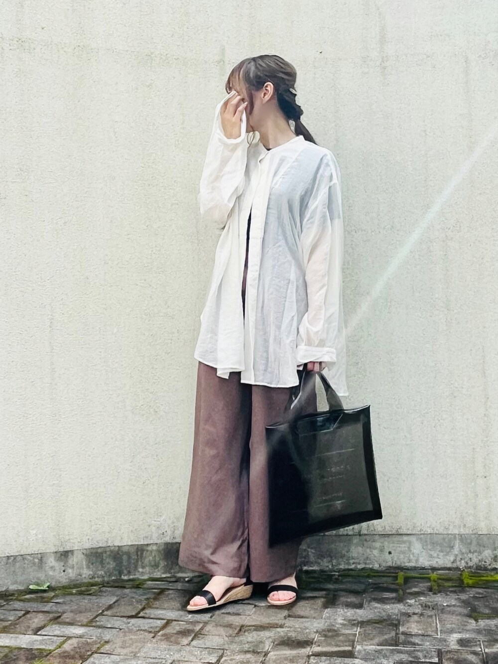 ブラック系のトートバッグ、ブラック系のサンダル、ブラウン系のその他パンツを着用したレディースの夏コーディネートの2枚目の写真