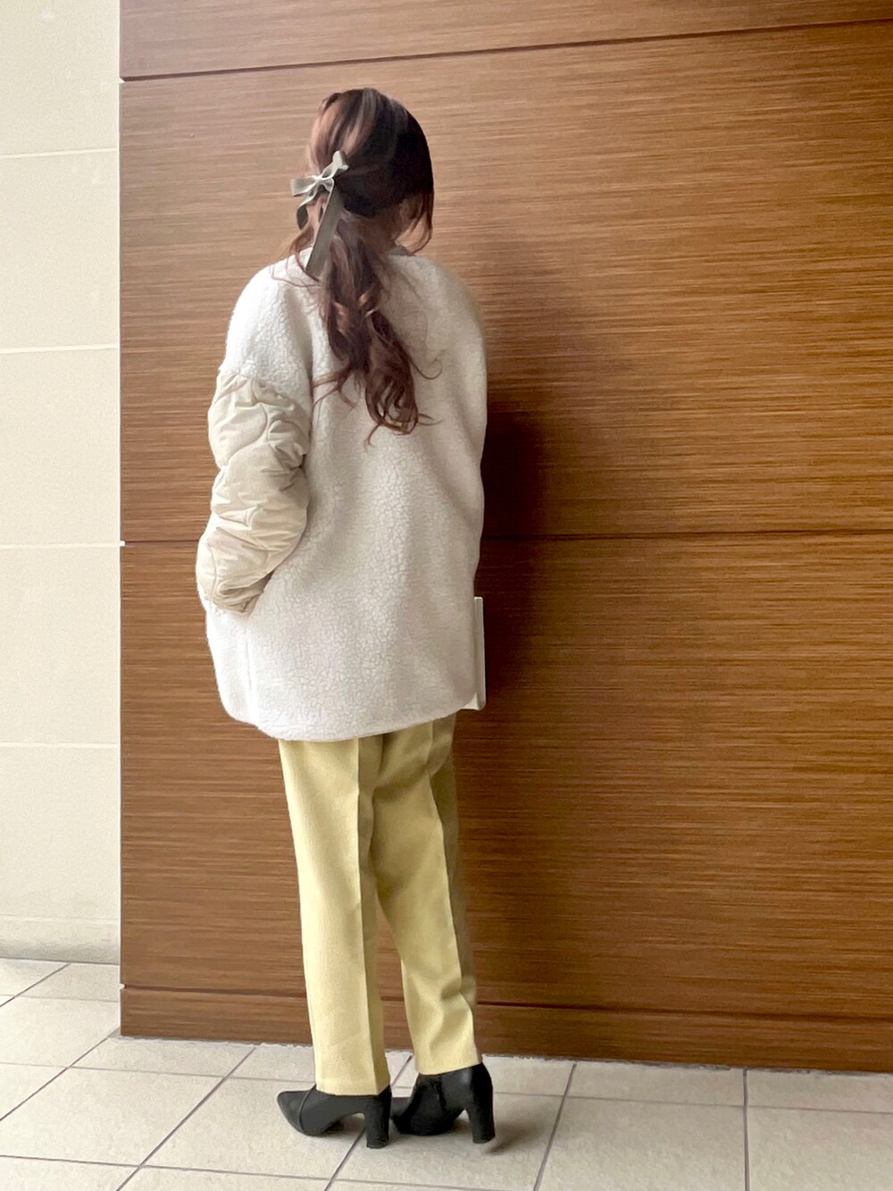 ホワイト系のブルゾン、ホワイト系のショルダーバッグ、イエロー系のその他パンツを着用したレディースの冬コーディネートの3枚目の写真
