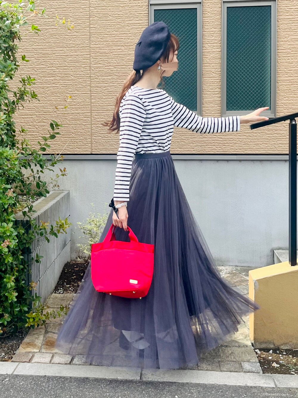 ブラック系のパンプス、グレー系のスカート、ホワイト系のTシャツ/カットソーを着用したレディースの秋コーディネートの2枚目の写真