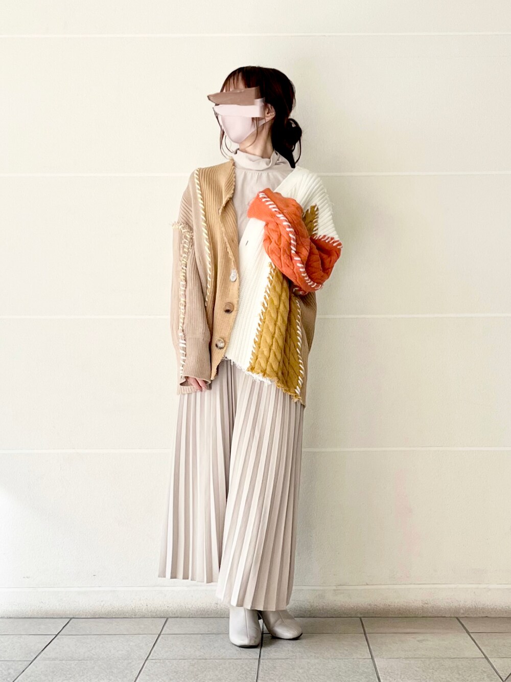 オレンジ系のカーディガン/ボレロ、ベージュ系のTシャツ/カットソー、ベージュ系のスカートを着用したレディースの冬コーディネートの3枚目の写真