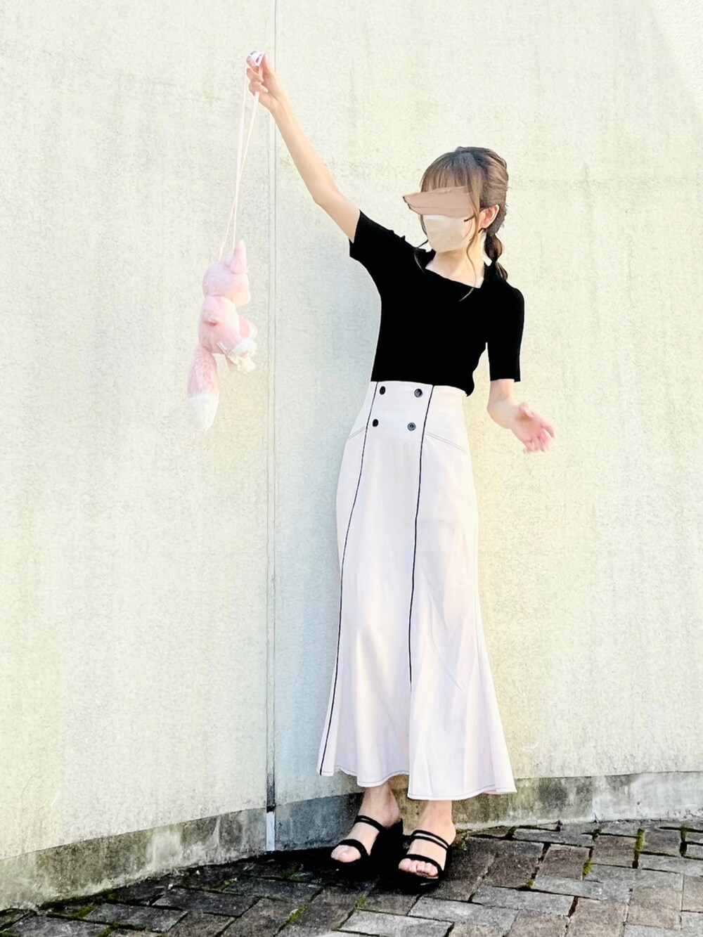 ブラック系のニット/セーター、ベージュ系のスカート、ブラック系のサンダルを着用したレディースの夏コーディネートの2枚目の写真