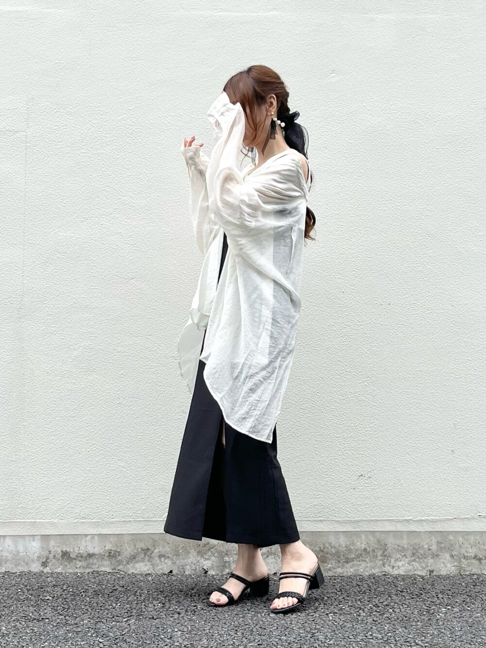 ブラック系のワンピース、ブラック系のサンダル、ホワイト系のシャツ/ブラウスを着用したレディースの春コーディネートの4枚目の写真