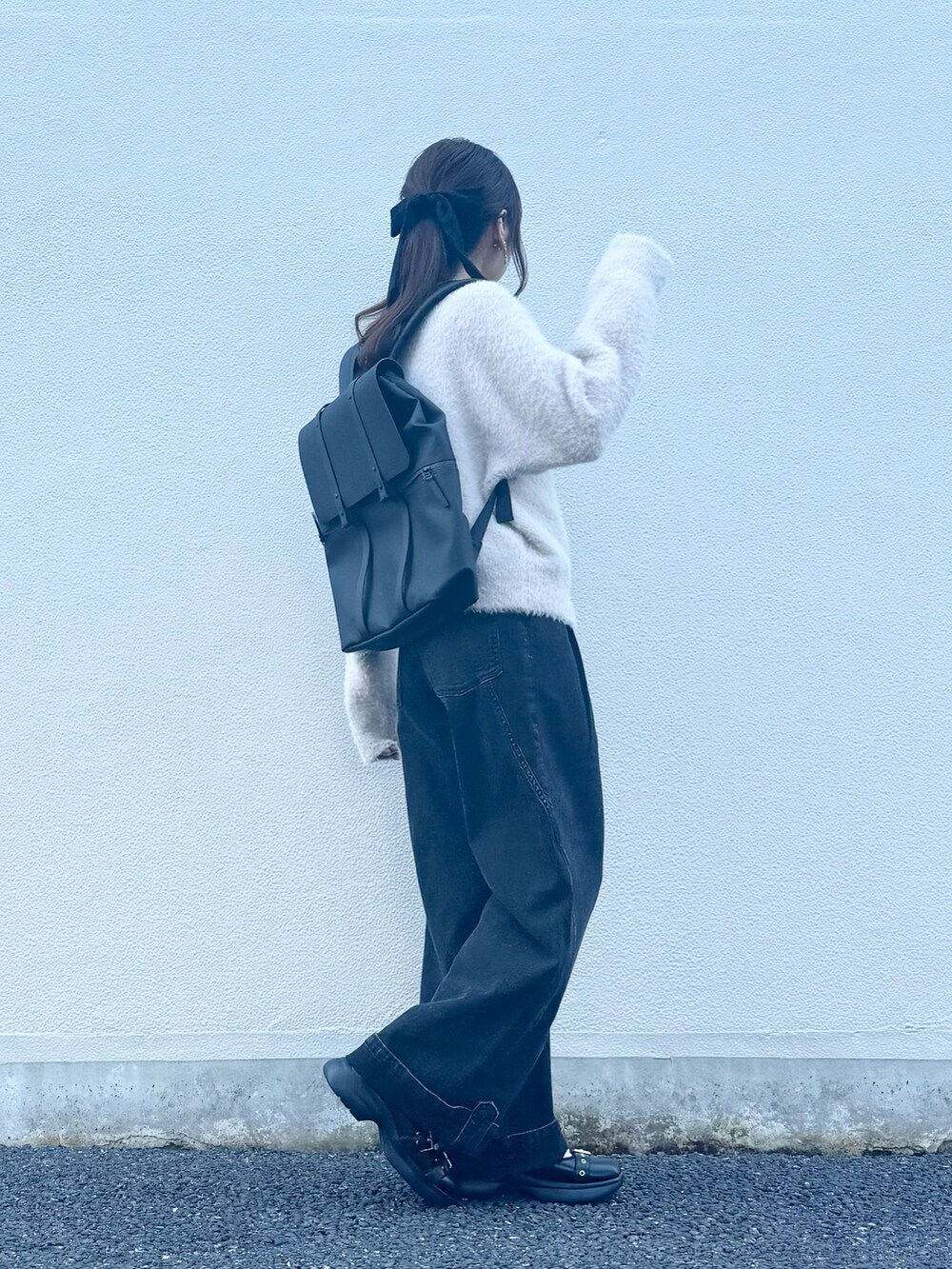 ブラック系のバックパック/リュック、グレー系のデニムパンツ、ブラック系のシューズを着用したレディースの秋コーディネートの3枚目の写真
