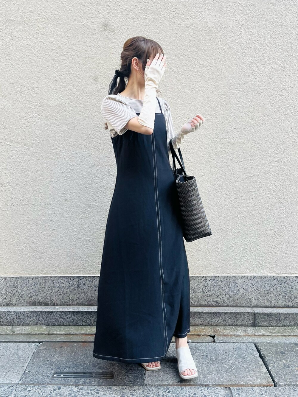 ブラウン系のバッグ、ブラック系のワンピース、ホワイト系のニット/セーターを着用したレディースの春コーディネートの5枚目の写真