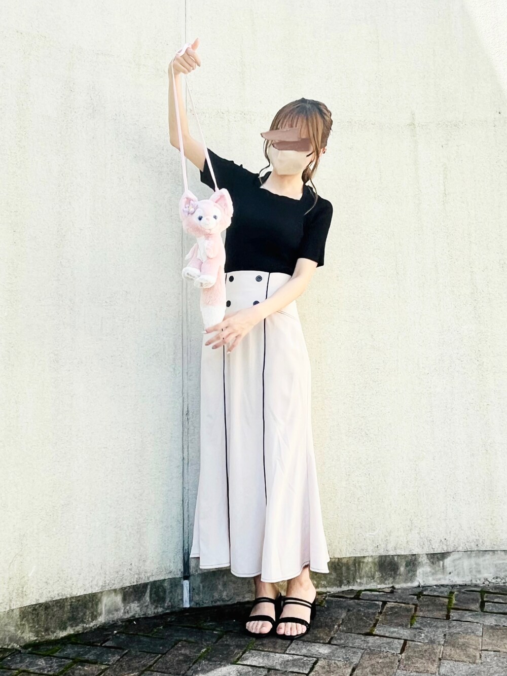 ブラック系のニット/セーター、ベージュ系のスカート、ブラック系のサンダルを着用したレディースの夏コーディネートの3枚目の写真