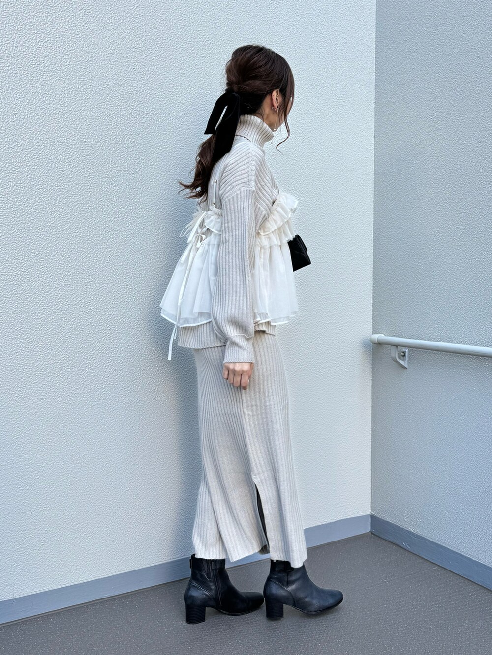 ブラック系のブーツ、ベージュ系のワンピース、ホワイト系のシャツ/ブラウスを着用したレディースの冬コーディネートの4枚目の写真