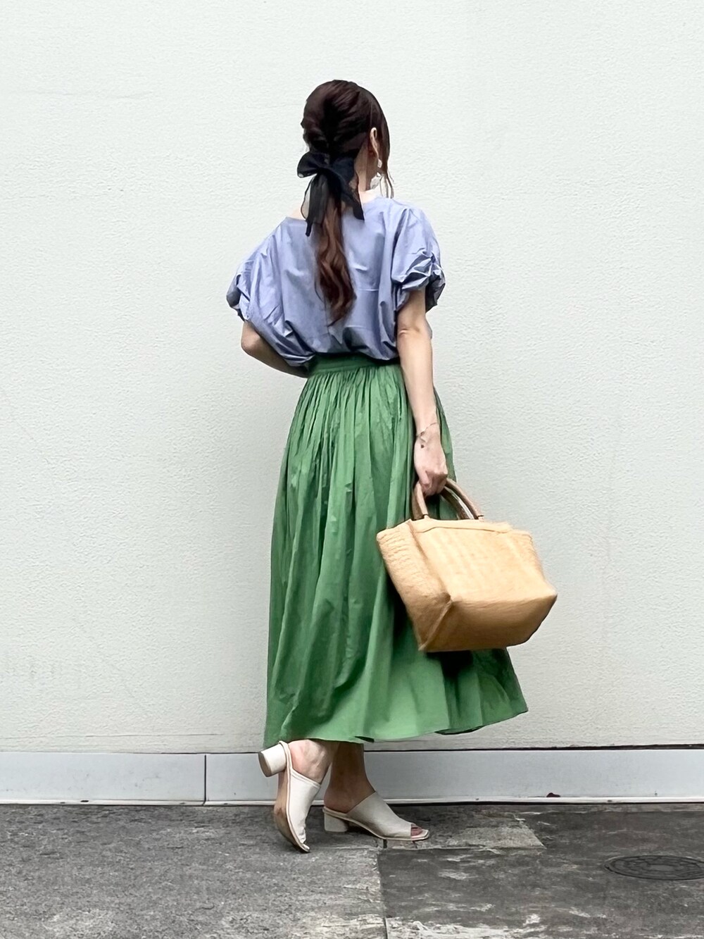 ブルー系のTシャツ/カットソー、ゴールド系のブレスレット、グレー系のスマホグッズを着用したレディースの夏コーディネートの2枚目の写真