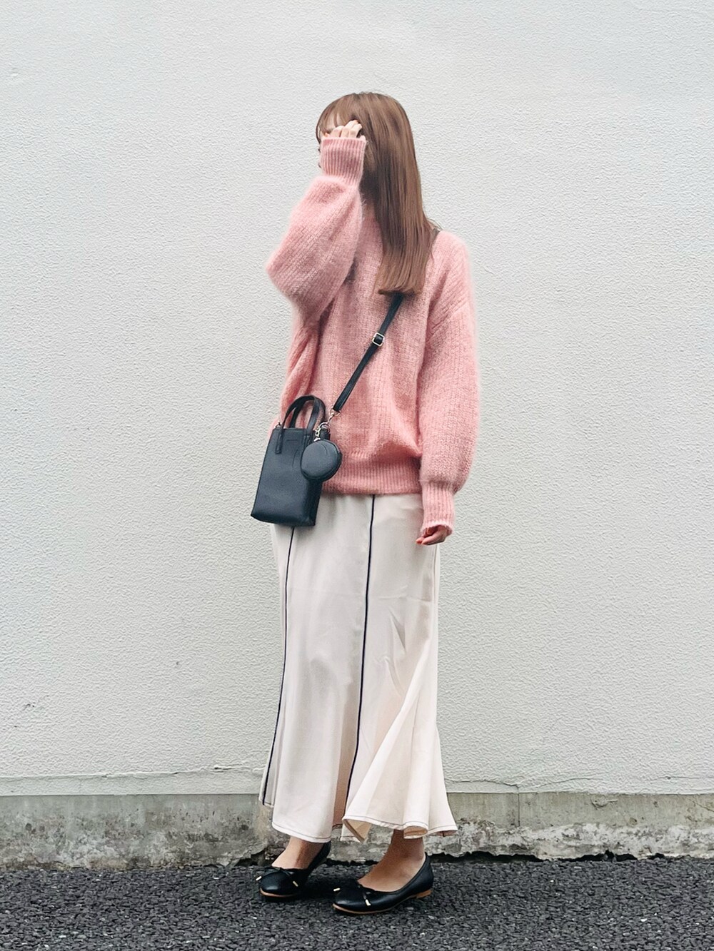 ピンク系のニット/セーター、ベージュ系のスカート、ブラック系のバレエシューズを着用したレディースの春コーディネートの4枚目の写真