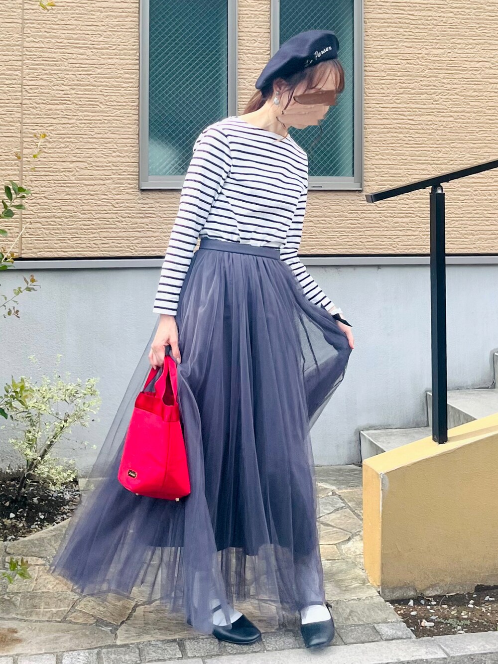 ブラック系のパンプス、グレー系のスカート、ホワイト系のTシャツ/カットソーを着用したレディースの秋コーディネートの3枚目の写真