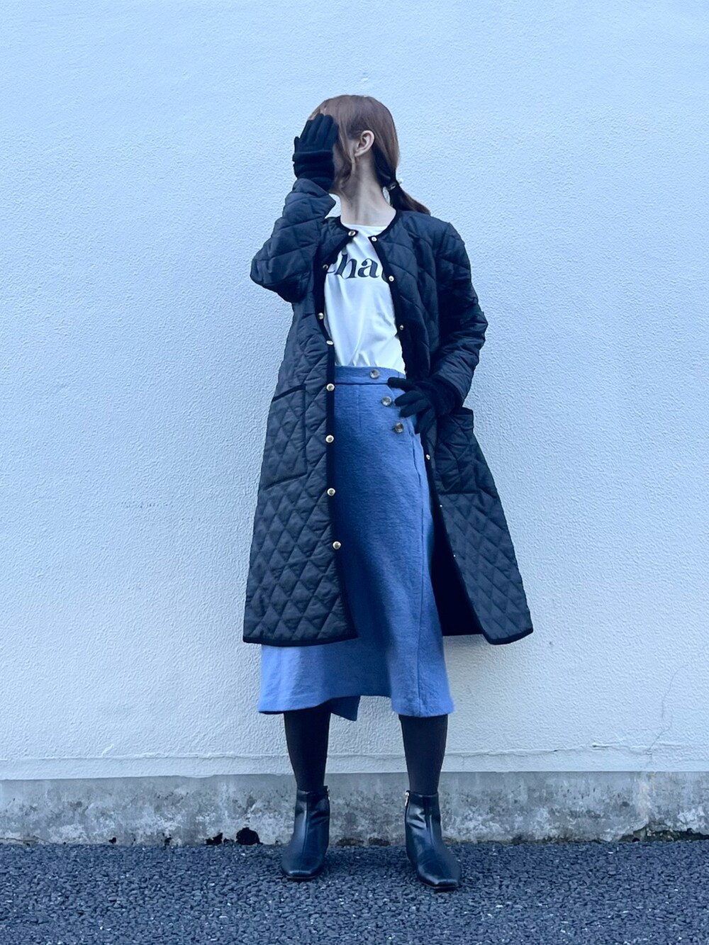 ブラック系のその他アウター、ホワイト系のTシャツ/カットソー、ブルー系のスカートを着用したレディースの冬コーディネートの2枚目の写真
