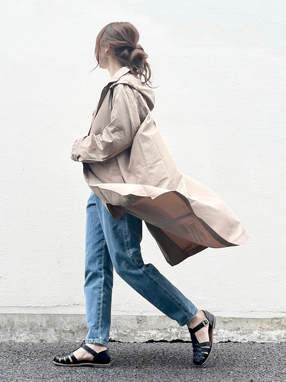 ブルー系のデニムパンツ、ホワイト系のTシャツ/カットソー、ブラック系のサンダルを着用したレディースの春コーディネートの2枚目の写真