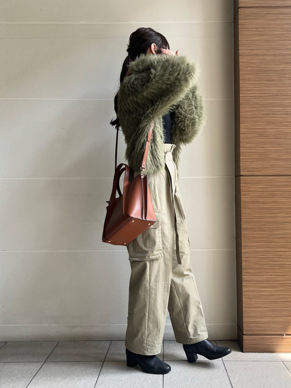 ブラック系のブーツ、ブラウン系のバッグ、グリーン系のカーディガン/ボレロを着用したレディースの秋コーディネートの5枚目の写真