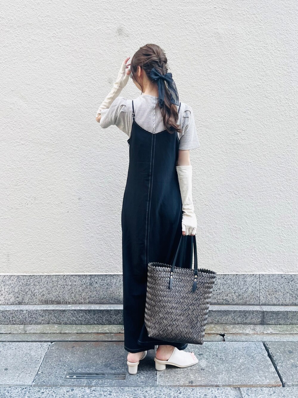 ブラウン系のバッグ、ブラック系のワンピース、ホワイト系のニット/セーターを着用したレディースの春コーディネートの3枚目の写真