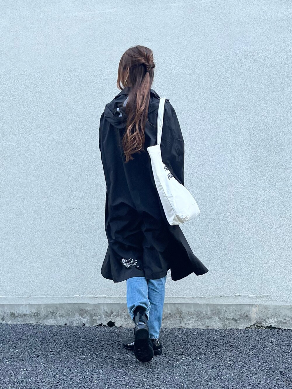ブラック系のレインシューズ、ホワイト系のトートバッグ、ブルー系のデニムパンツを着用したレディースの夏コーディネートの3枚目の写真
