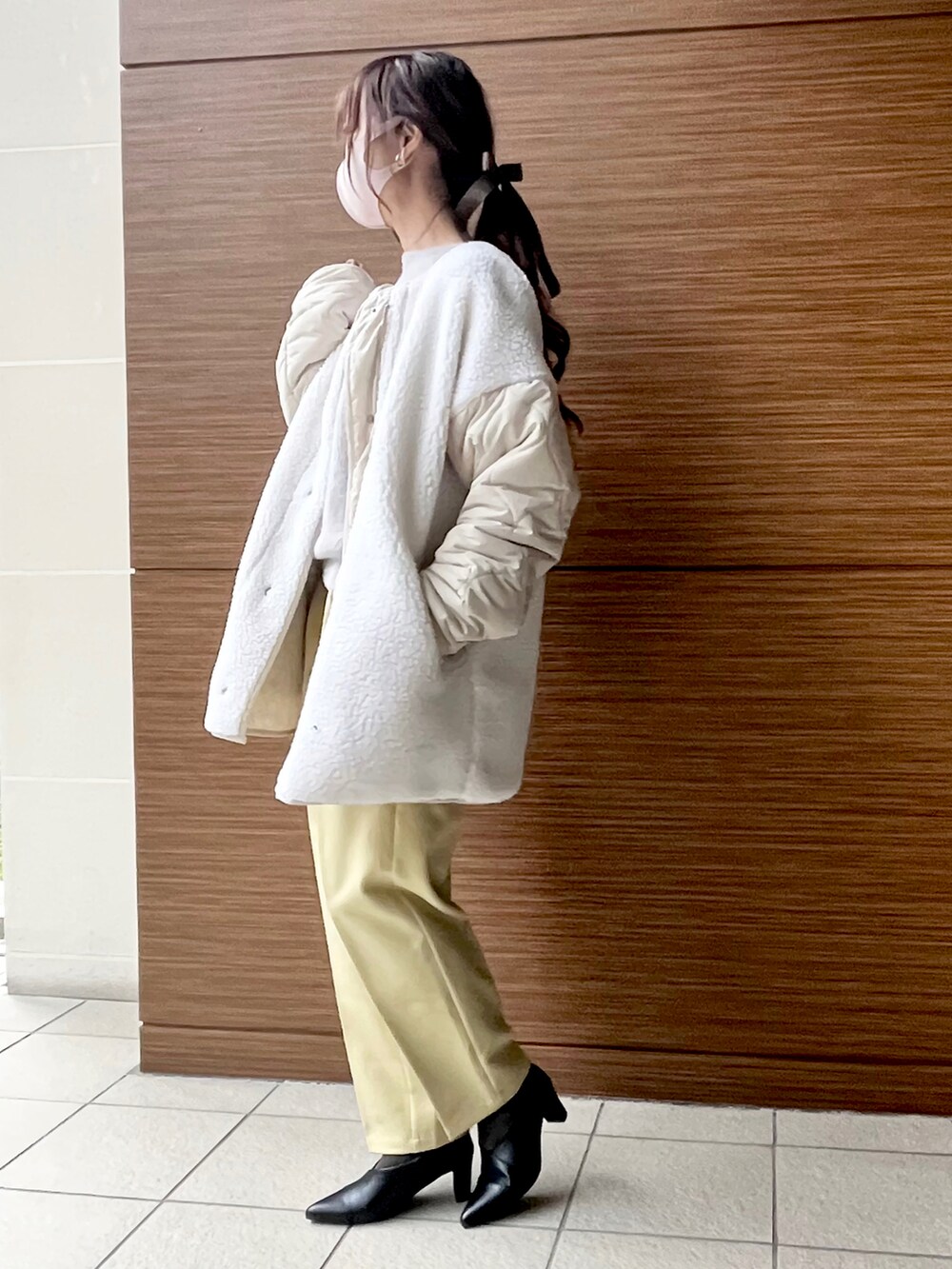 ホワイト系のブルゾン、ホワイト系のショルダーバッグ、イエロー系のその他パンツを着用したレディースの冬コーディネートの2枚目の写真