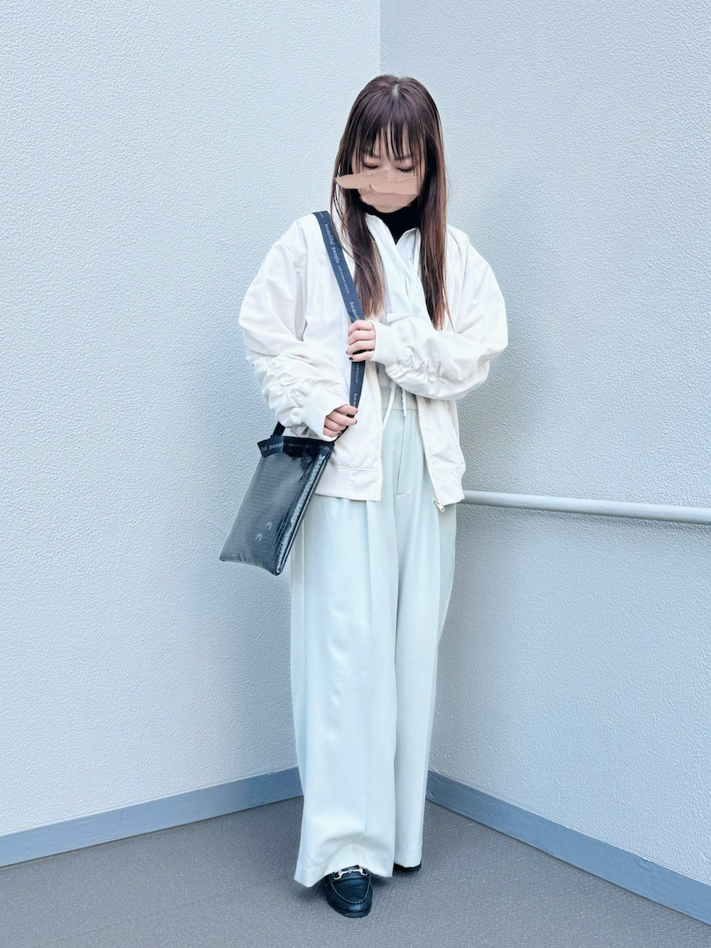 ブラック系のショルダーバッグ、ホワイト系のブルゾン、ホワイト系のシャツ/ブラウスを着用したレディースの春コーディネートの2枚目の写真