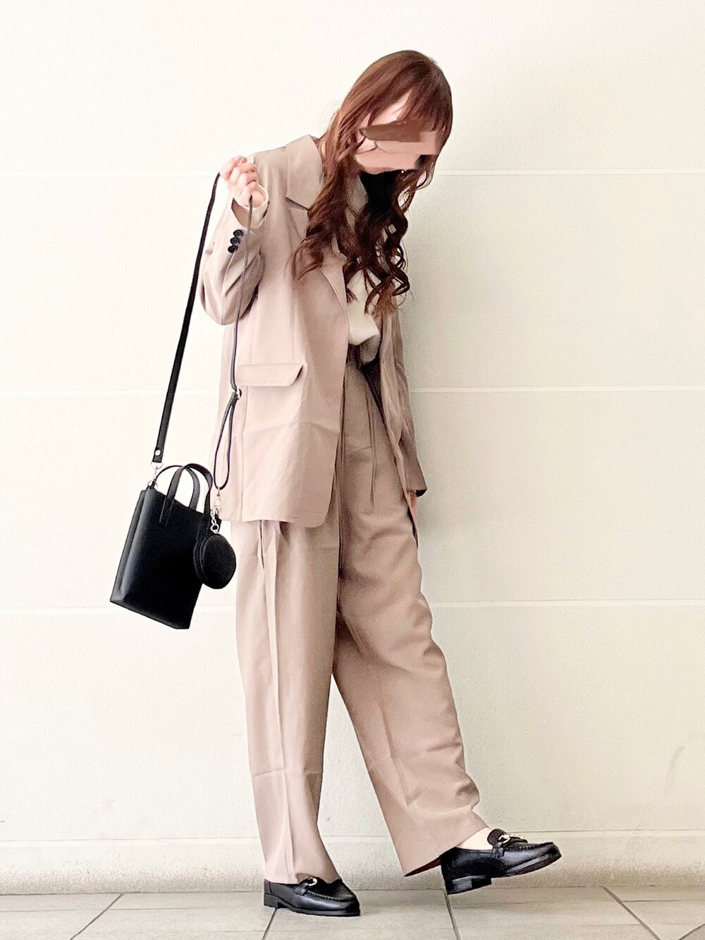 グレー系のテーラードジャケット、ブラック系のローファー、ホワイト系のニット/セーターを着用したレディースの春コーディネートの3枚目の写真