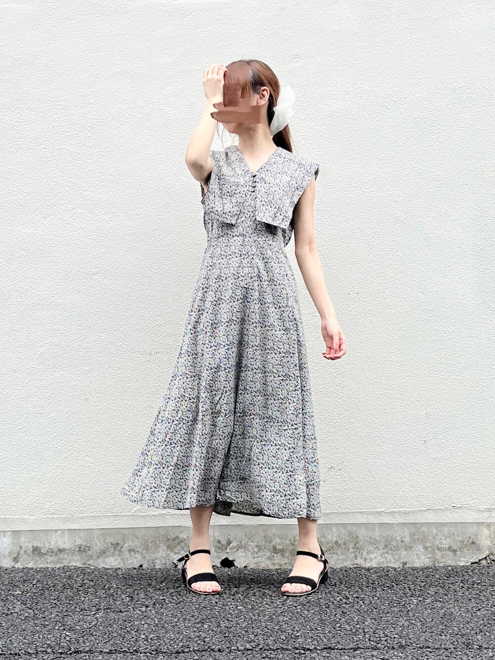 ブラック系のワンピース、ブラック系のサンダル、ホワイト系のシュシュを着用したレディースの春コーディネートの4枚目の写真