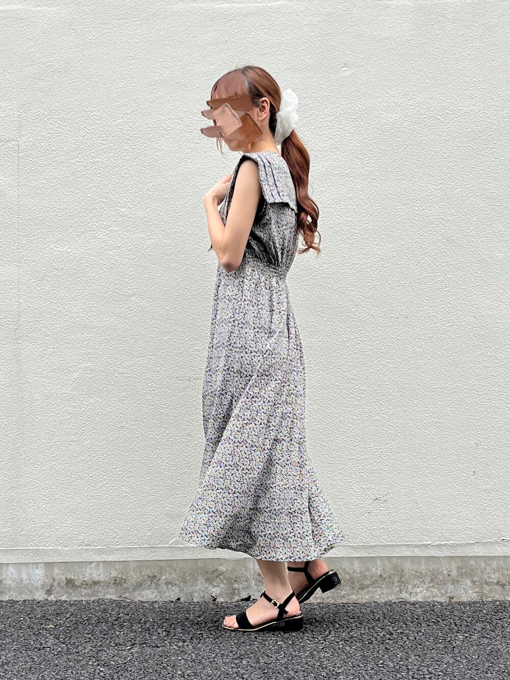 ブラック系のワンピース、ブラック系のサンダル、ホワイト系のシュシュを着用したレディースの春コーディネートの3枚目の写真