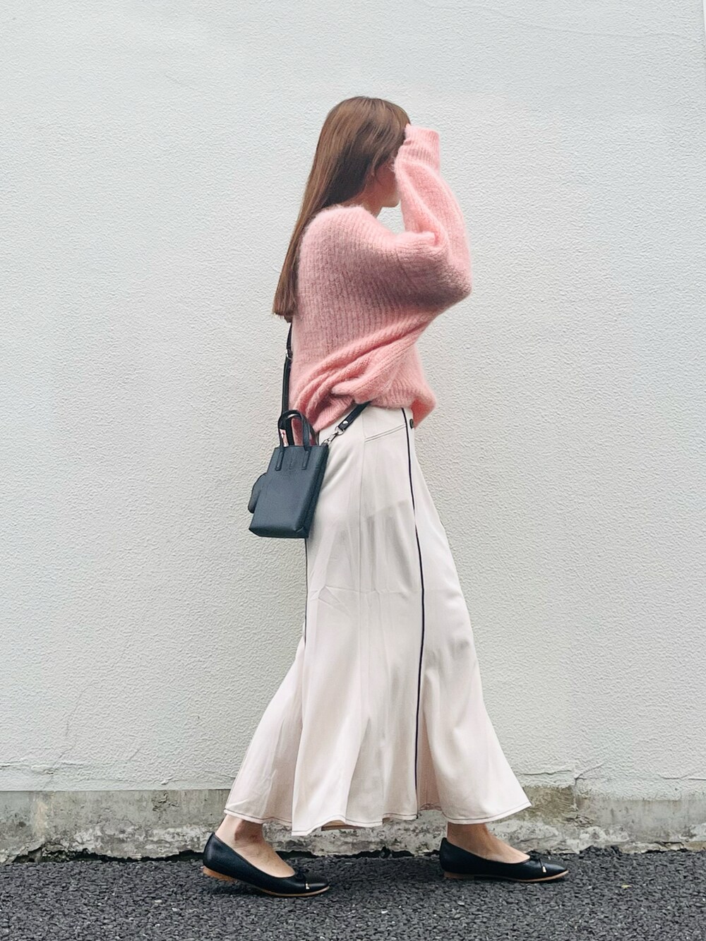 ピンク系のニット/セーター、ベージュ系のスカート、ブラック系のバレエシューズを着用したレディースの春コーディネートの3枚目の写真