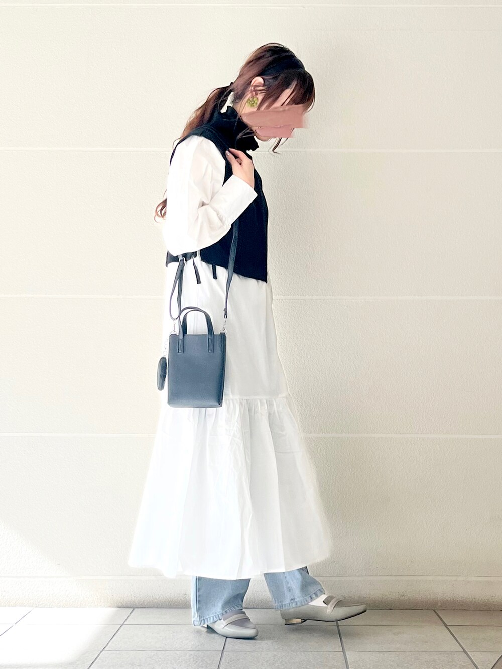 ホワイト系のワンピース、グリーン系のパンプス、ブラック系のショルダーバッグを着用したレディースの冬コーディネートの3枚目の写真