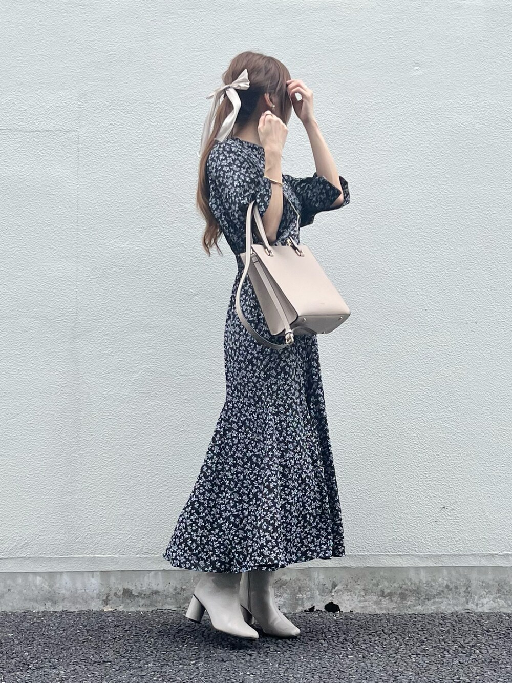 ベージュ系のバッグ、ブラック系のワンピース、ホワイト系のブーツを着用したレディースの秋コーディネートの2枚目の写真