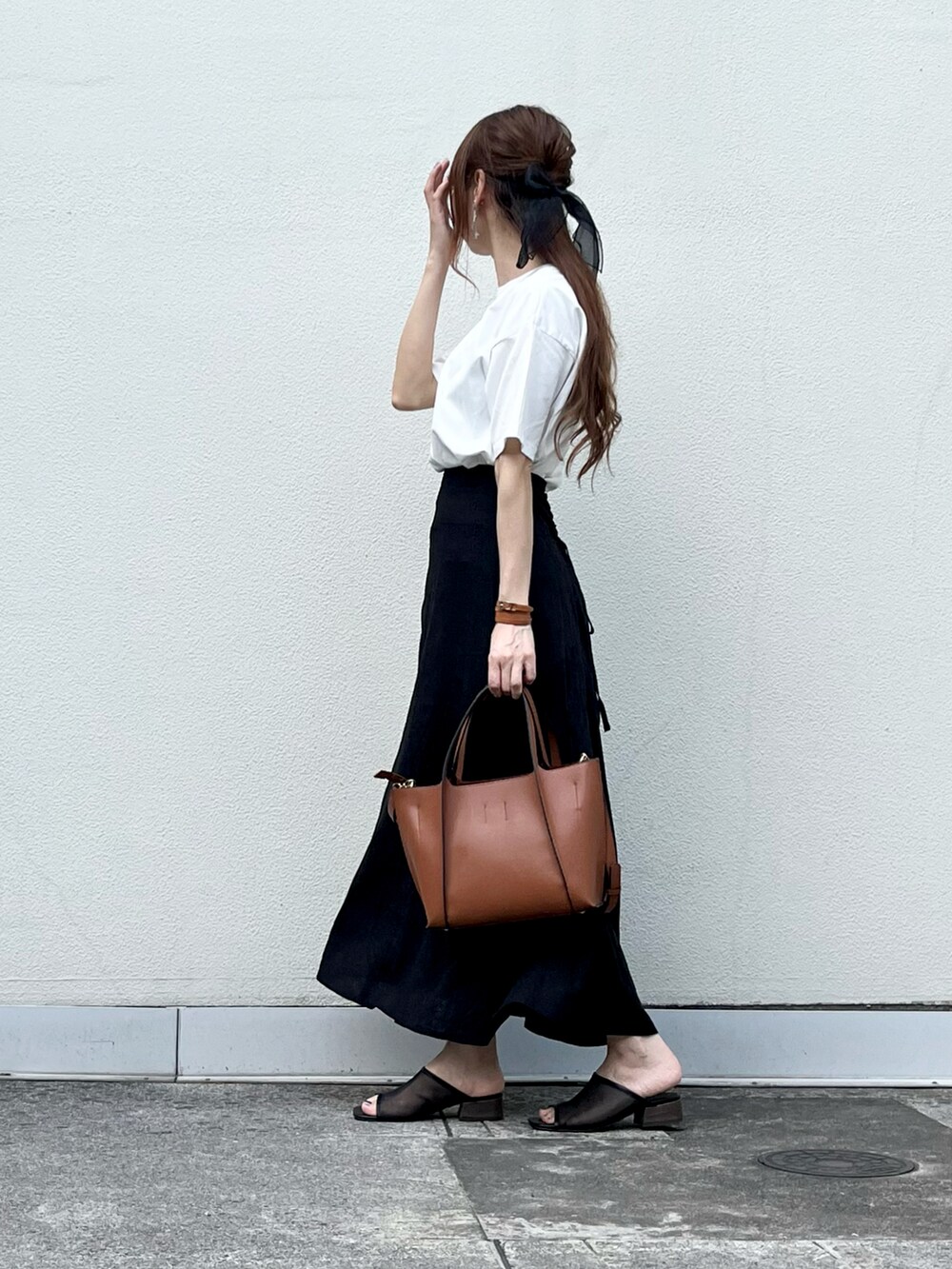 ブラウン系のバッグ、ブラック系のスカート、ブラック系のその他シューズを着用したレディースの夏コーディネートの3枚目の写真