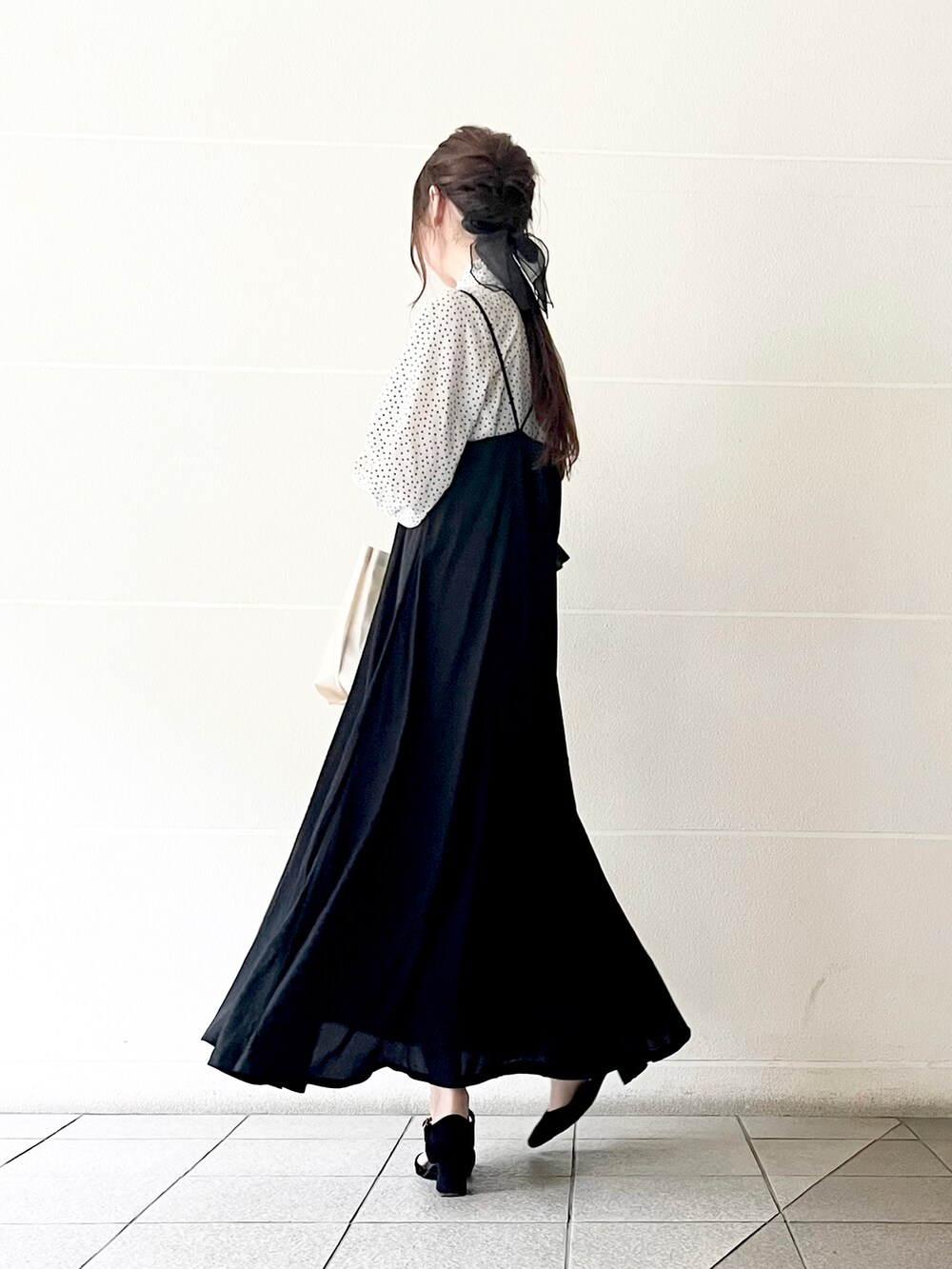 ブラック系のワンピース、ホワイト系のシャツ/ブラウス、グリーン系のカーディガン/ボレロを着用したレディースの春コーディネートの2枚目の写真