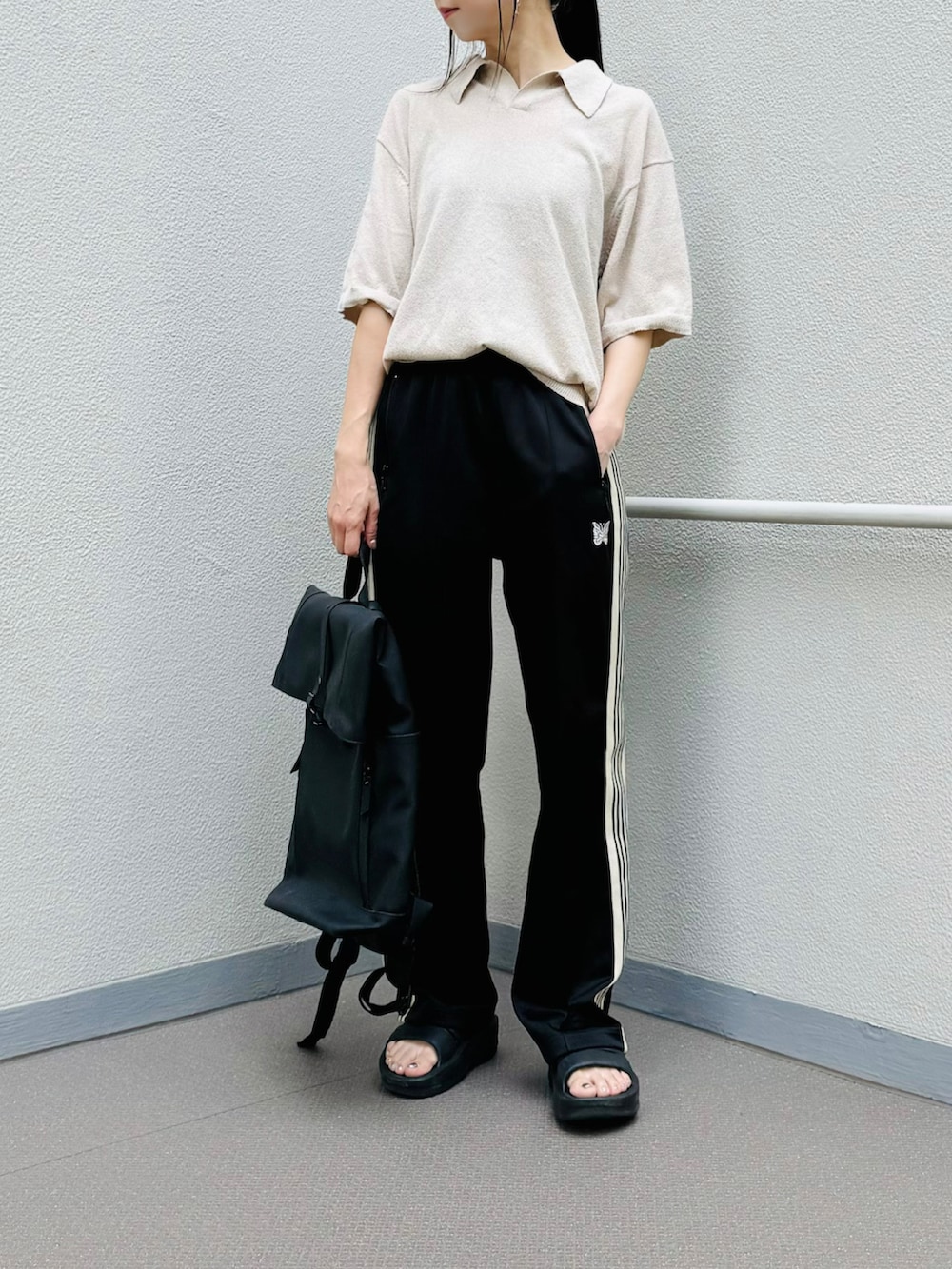 ブラック系のバックパック/リュック、ブラック系のサンダル、ブラック系のパンツを着用したレディースの夏コーディネートの3枚目の写真