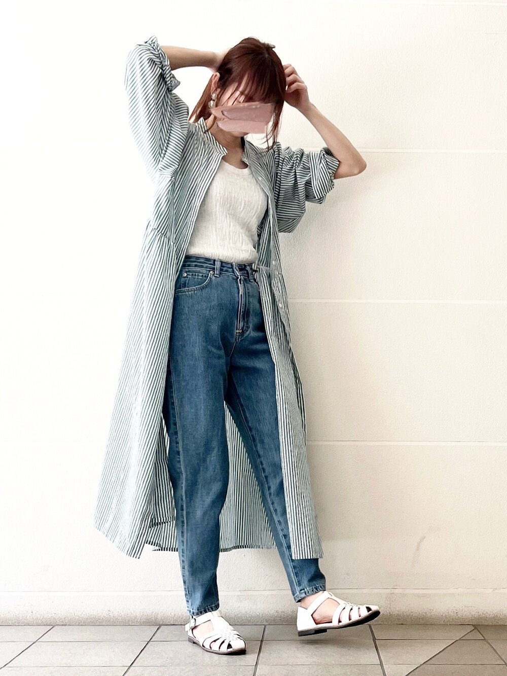 ブルー系のデニムパンツ、ホワイト系のタンクトップ、グリーン系のワンピースを着用したレディースの春コーディネートの2枚目の写真