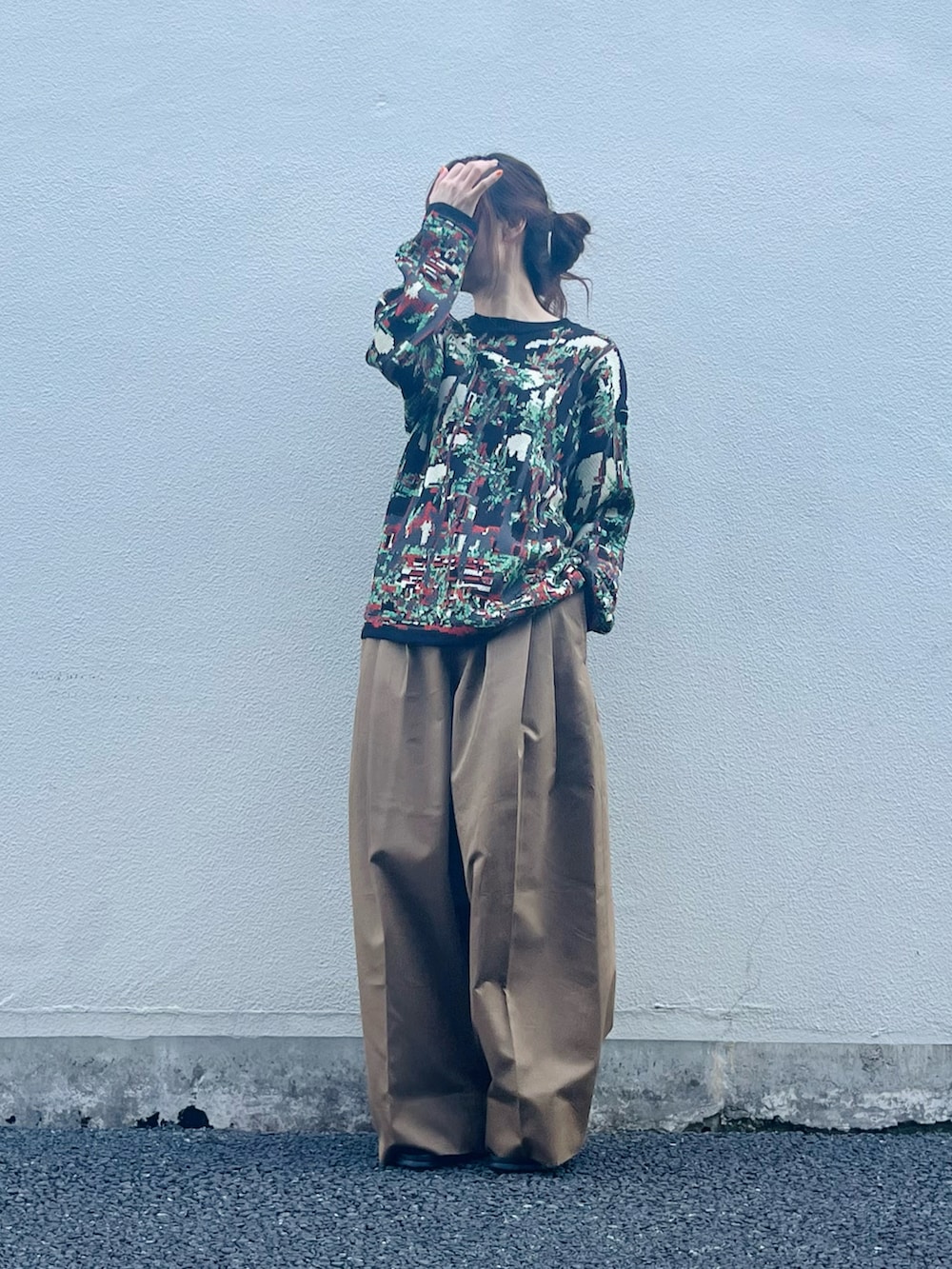 ブラック系のトップス、ブラウン系のパンツ、ブラック系のサンダルを着用したレディースの春コーディネートの4枚目の写真