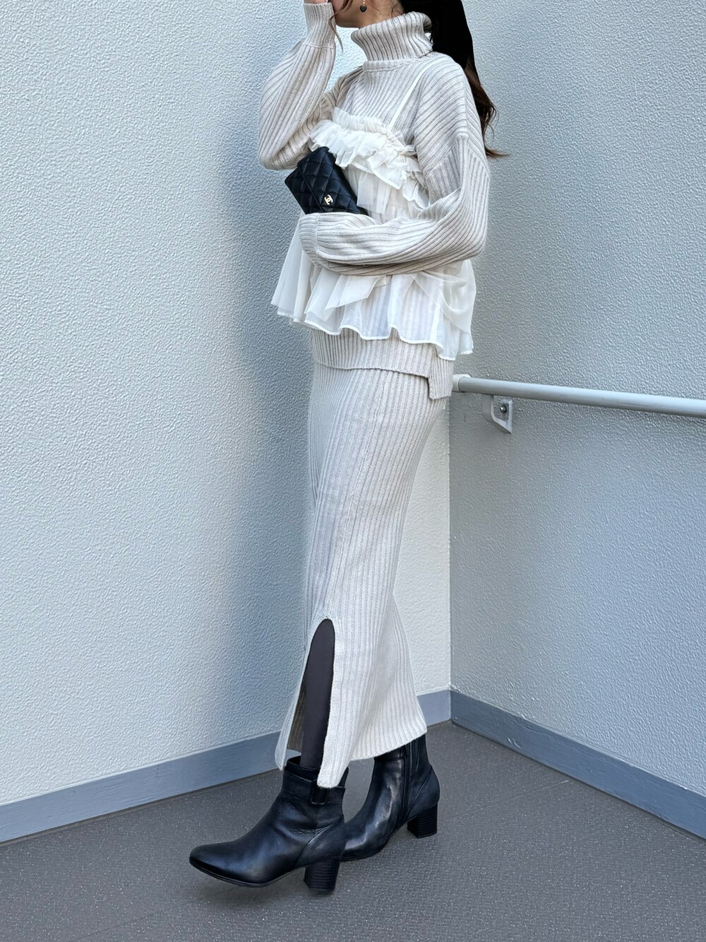 ブラック系のブーツ、ベージュ系のワンピース、ホワイト系のシャツ/ブラウスを着用したレディースの冬コーディネートの5枚目の写真