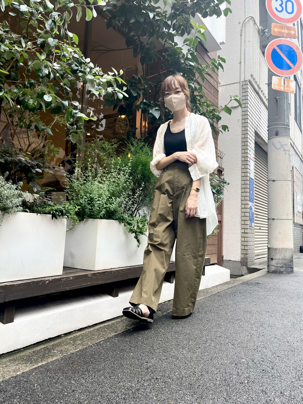 ブラック系のタンクトップ、グリーン系のその他パンツ、ブラック系のサンダルを着用したレディースの夏コーディネートの4枚目の写真