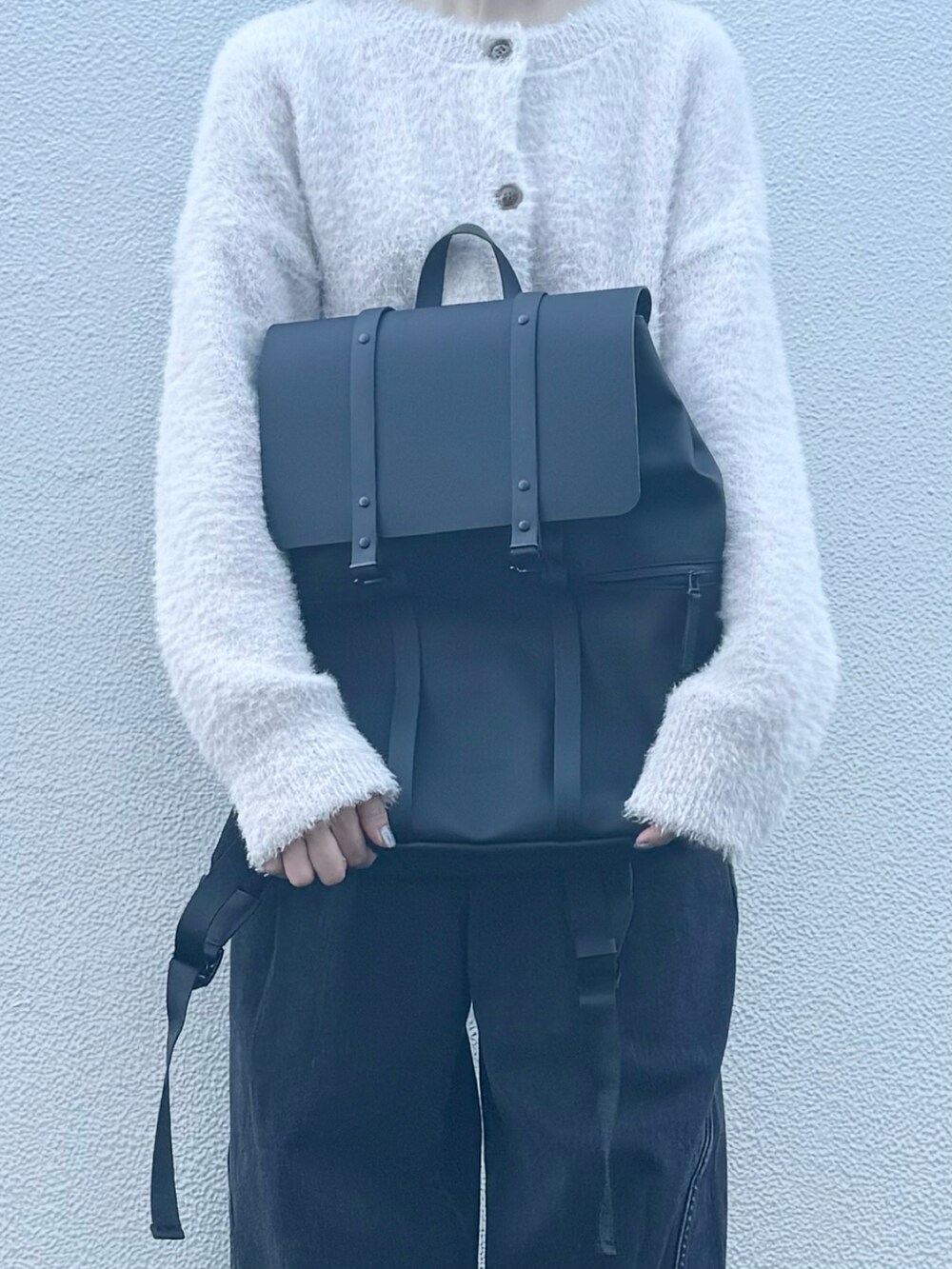 ブラック系のバックパック/リュック、グレー系のデニムパンツ、ブラック系のシューズを着用したレディースの秋コーディネートの4枚目の写真