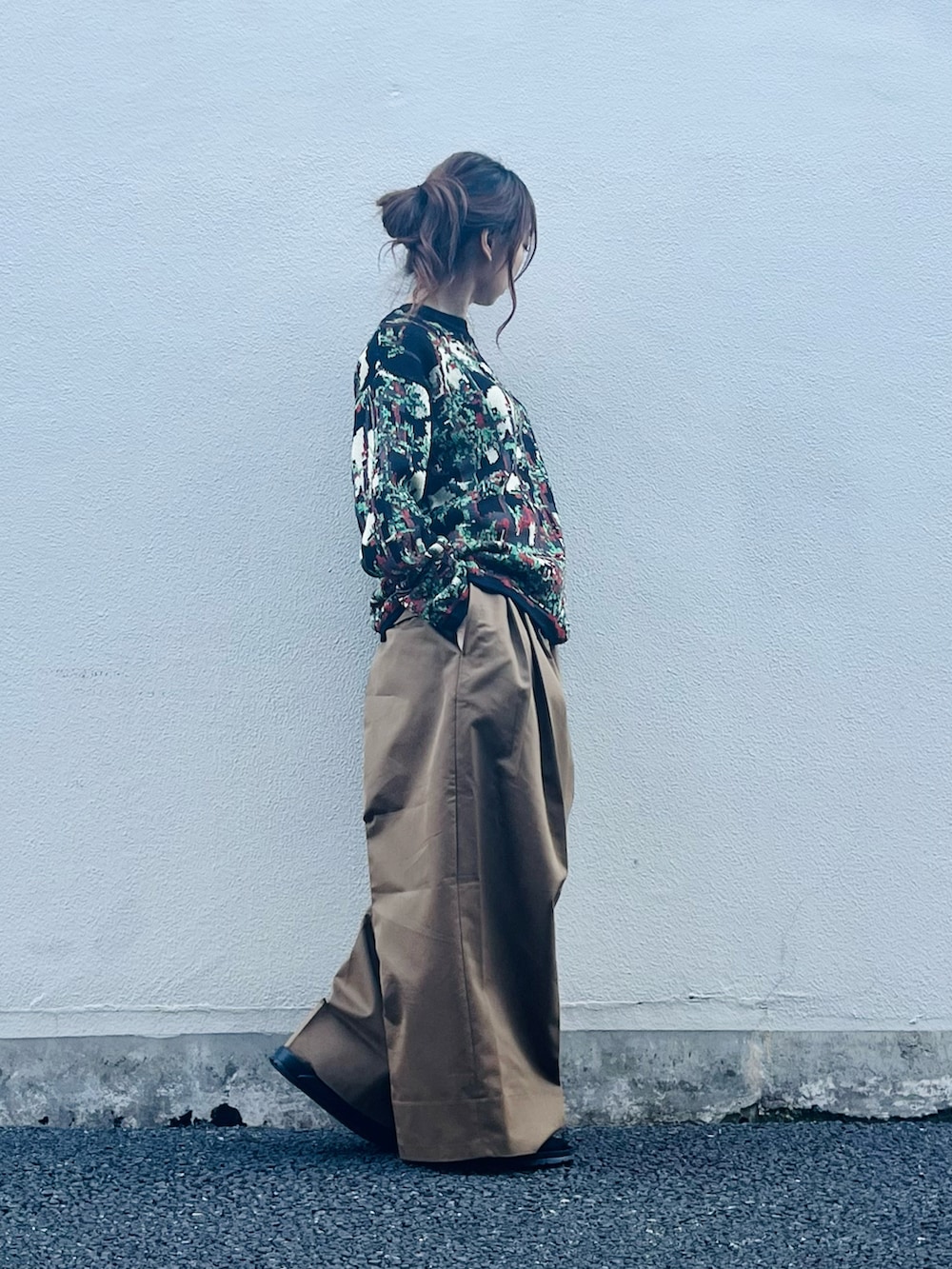 ブラック系のトップス、ブラウン系のパンツ、ブラック系のサンダルを着用したレディースの春コーディネートの2枚目の写真