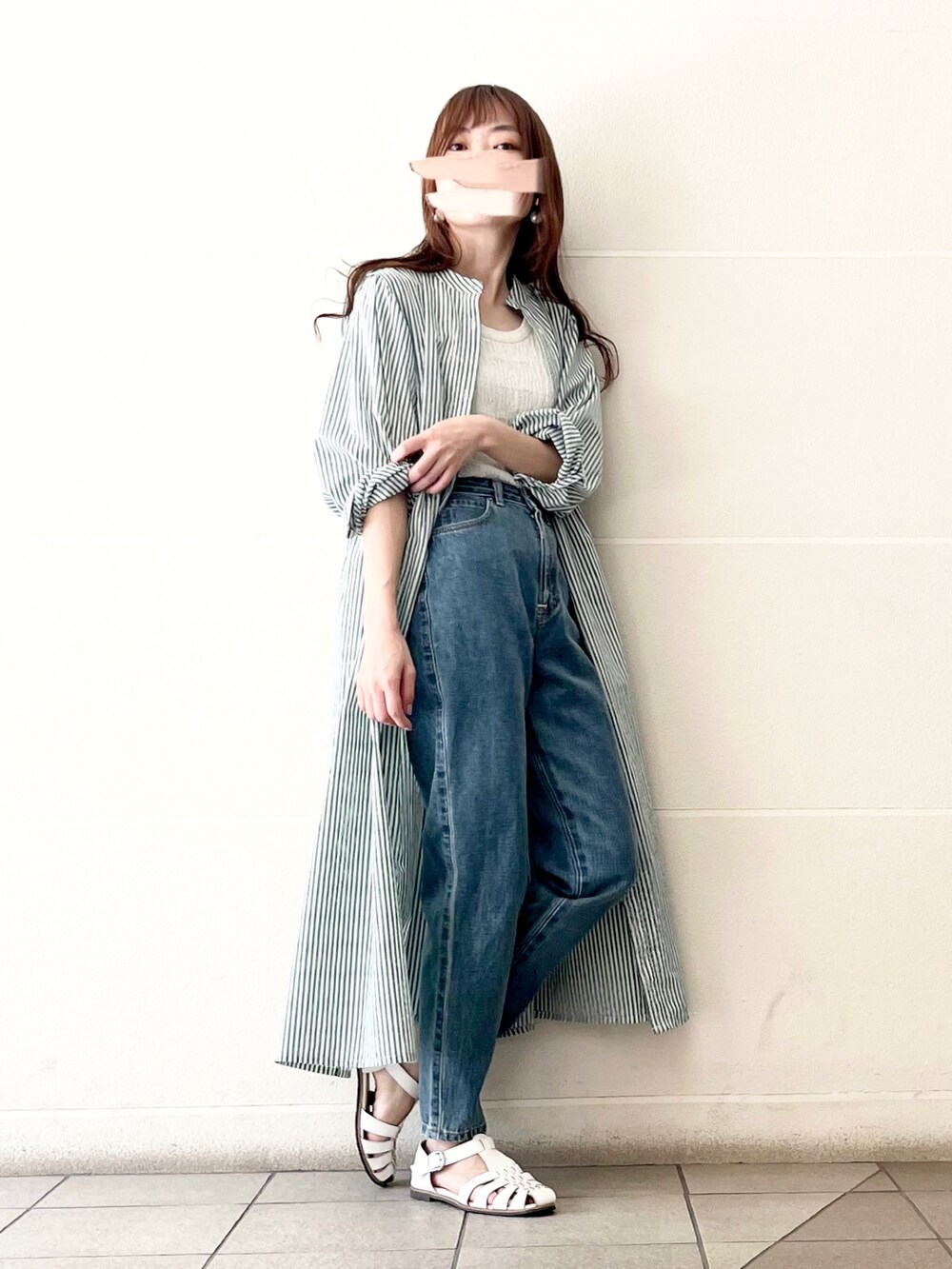 ブルー系のデニムパンツ、ホワイト系のタンクトップ、グリーン系のワンピースを着用したレディースの春コーディネートの4枚目の写真