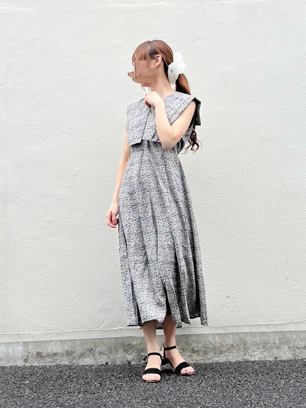 ブラック系のワンピース、ブラック系のサンダル、ホワイト系のシュシュを着用したレディースの春コーディネートの2枚目の写真