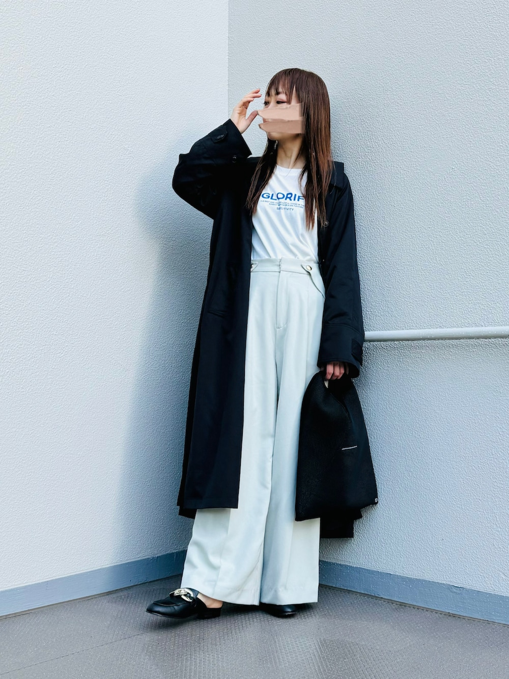 ブラック系のステンカラーコート、ブラック系のトートバッグ、ブラック系のスリッポンを着用したレディースの春コーディネートの2枚目の写真